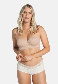 Huidskleurige strapless beha met gevormde cups, een gladde textuur en flexibele onderdraad; gecombineerd met witte boyshorts met een kanten tailleband.