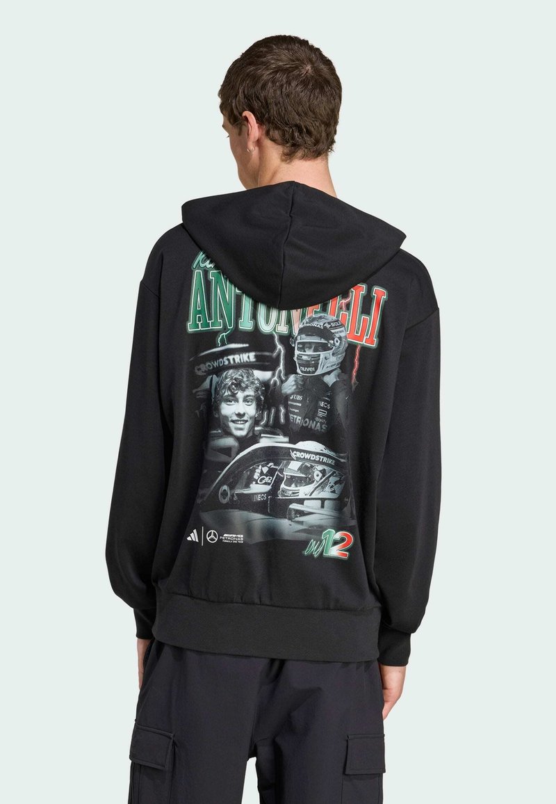 Hoodie noir avec une impression graphique au dos présentant plusieurs images, y compris une voiture et deux visages, avec du texte en accents rouges et verts.
