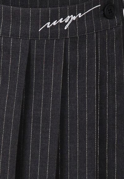Jupe plissée gris foncé avec des rayures blanches, dotée d'un logo brodé et d'une fermeture à bouton à la taille.