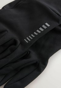 Czarne rękawiczki wykonane z miękkiego, elastycznego materiału, z teksturowaną powierzchnią i odblaskowymi akcentami w liniowym wzorze wzdłuż nadgarstka.