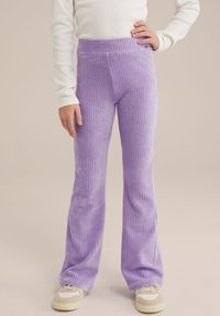 Pantaloni evazați din corduroy violet cu dungi verticale și talie elastică, asortați cu adidași de culoare deschisă.