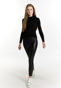 Top lungo attillato nero a costine, leggings in pelle nera a vita alta e sneakers alte multicolori con dettagli bianchi, menta e rosa.