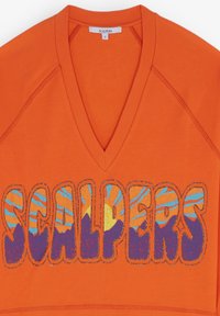 Sweatshirt à col en V orange avec un grand graphique "SCALPERS" et un design de coucher de soleil bleu et violet. Col et bords de manches côtelés. Texture douce.
