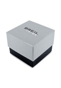 Boîte à bijoux carrée avec un couvercle en argent et une base noire. Présente le logo imprimé "BREIL TRIBE" sur le dessus. Texture lisse, design simple.