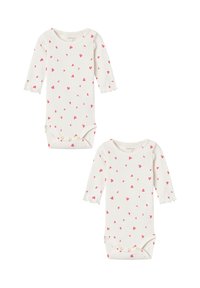Long-sleeve baby bodysuits in cream with small pink heart patterns, featuring scalloped cuffs and snap closures at the bottom. Two pieces included.