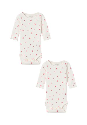 Long-sleeve baby bodysuits in cream with small pink heart patterns, featuring scalloped cuffs and snap closures at the bottom. Two pieces included.
