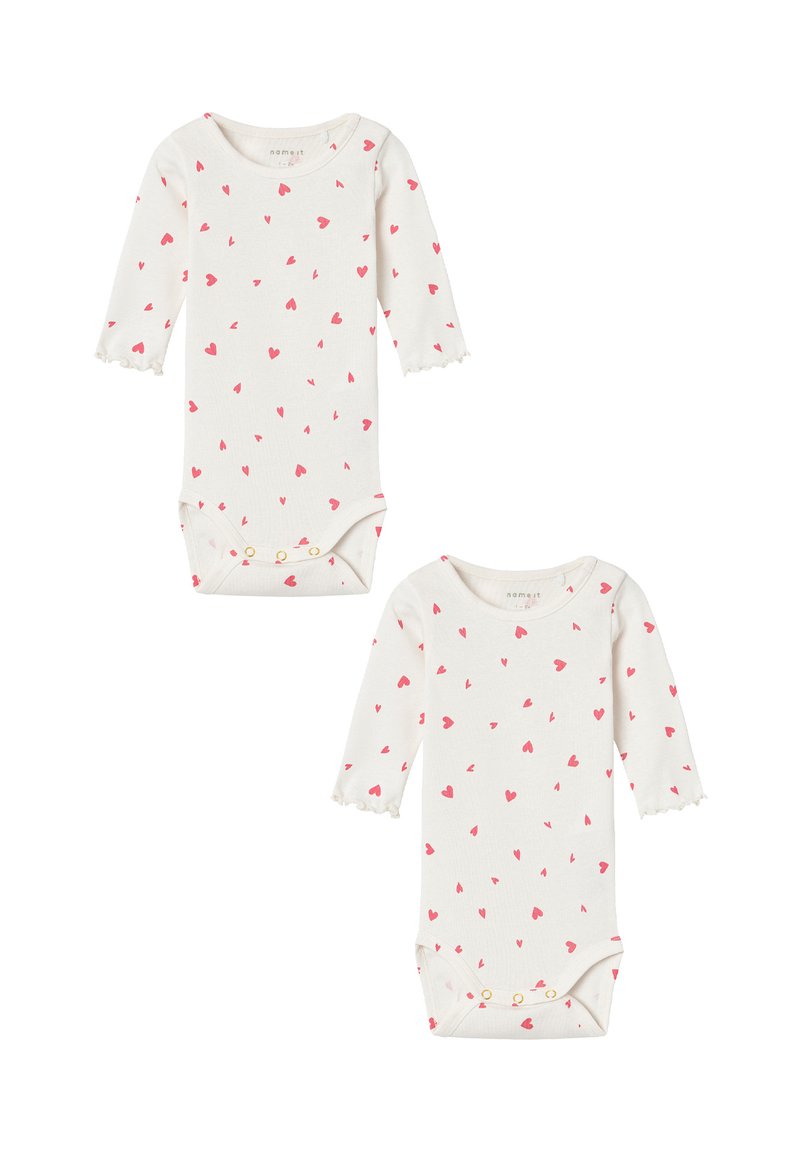Long-sleeve baby bodysuits in cream with small pink heart patterns, featuring scalloped cuffs and snap closures at the bottom. Two pieces included.