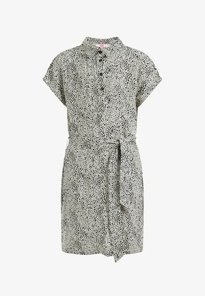 Robe à manches courtes avec col, motif moucheté noir et blanc, ceinture en tissu nouée à la taille.