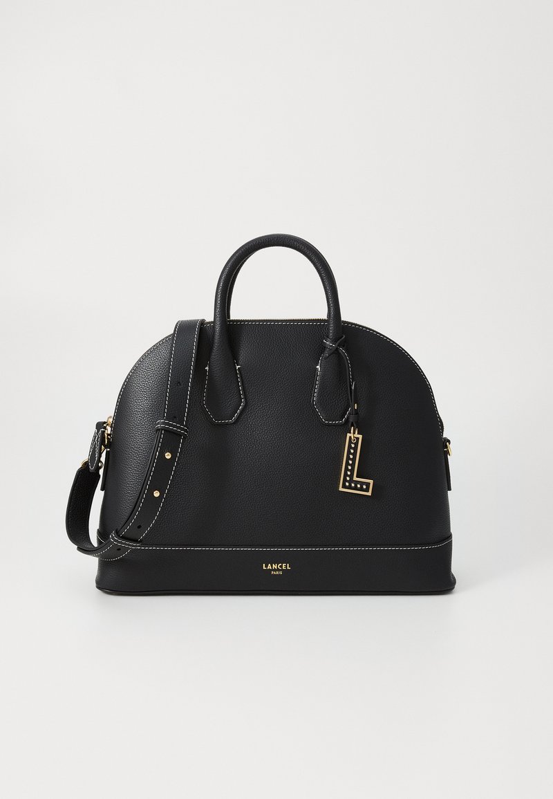 Bolsa de couro preta com forma arredondada, costura branca, alças superiores e uma alça de ombro destacável. Apresenta um detalhe de charme dourado.