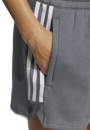 Grijze sportshorts met zijzakken, voorzien van contrasterende witte strepen langs de zijkanten en een zachte, gestructureerde stofafwerking.
