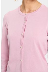 Rosa kofta i ribbad stickad kvalitet, med rund halsringning och sex pärlknappar på framsidan. Långa ärmar och figurnära passform.