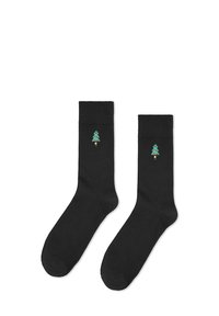 Czarne bawełniane skarpetki o jednolitej fakturze, z małym, zielonym haftowanym choinką na każdej skarpetce.