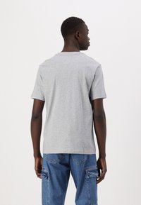Grå bomulds t-shirt med korte ærmer, rund hals og en afslappet pasform. Enkel design, glat tekstur og ingen synlige mønstre eller accenter.