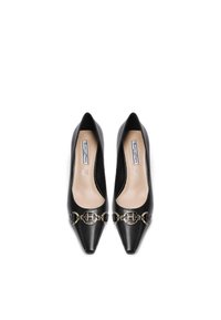 Tacchi a spillo in pelle nera con punta affusolata, caratterizzati da un dettaglio in catena dorata sulla parte anteriore e foderati in beige, con una texture liscia e un design elegante.