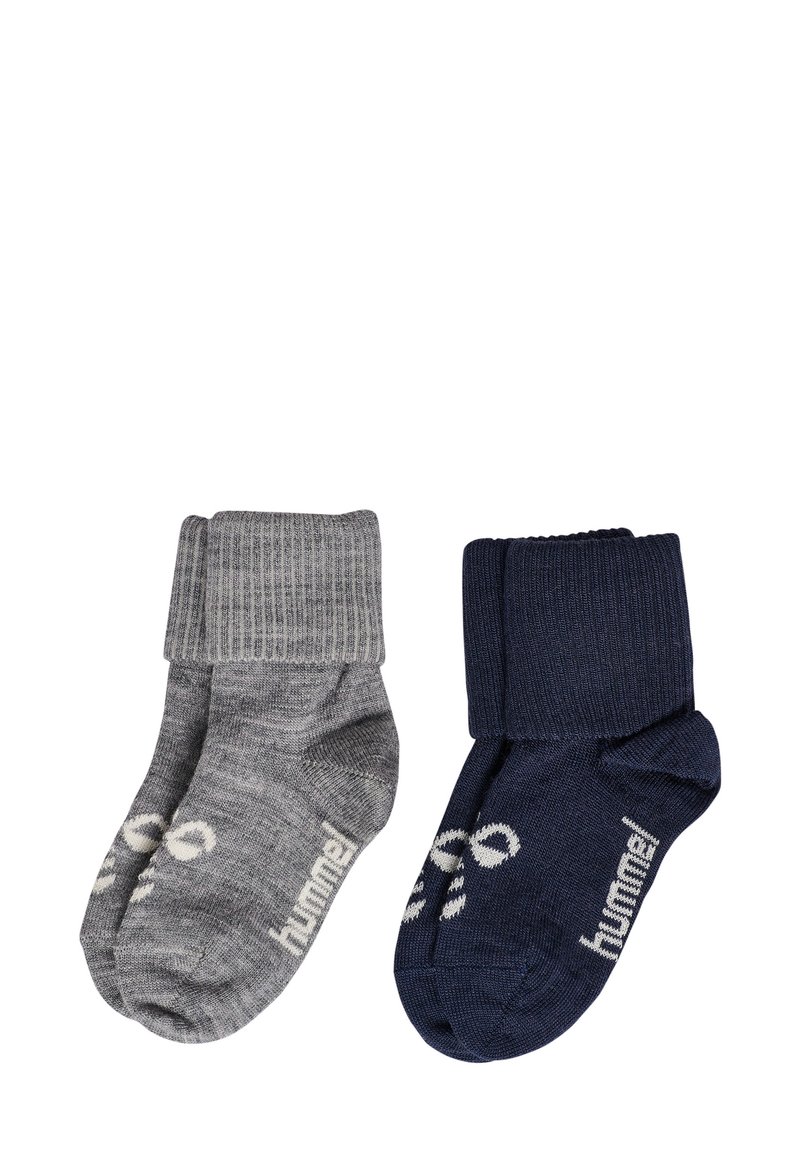 Två par strumpor: ett grått med ribbad mudd och logotyp, ett marinblått med liknande mudd och logotyp. Båda har en mjuk textur och är ankellånga.
