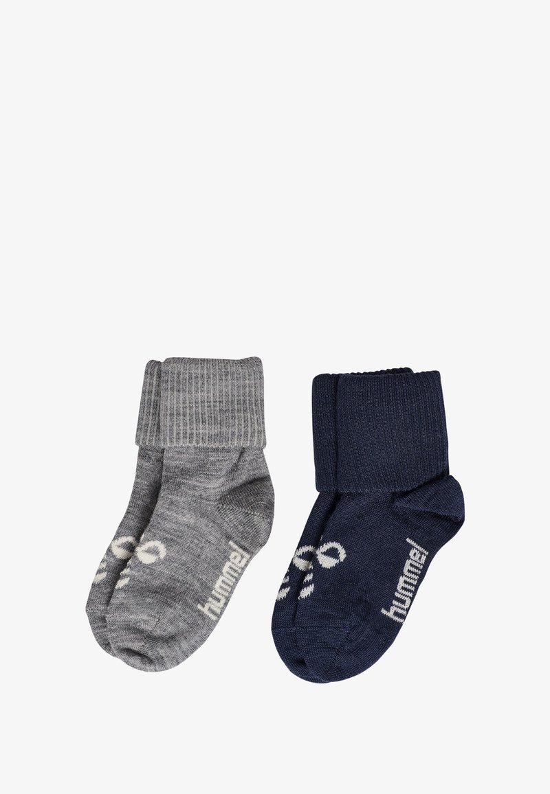 Dwie pary skarpetek: jedna szara z prążkowanym ściągaczem i logo, druga granatowa o podobnym ściągaczu i logo. Obie mają miękką teksturę i długość do kostki.