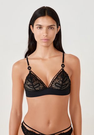 Black lace bralette with a triangular shape, featuring adjustable straps and a soft underband. Detailed lace pattern with semi-sheer sections.