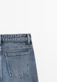 Jeans in denim di blu medio con una classica linea dritta, dotati di vita media, accenti cuciti e una singola tasca posteriore.