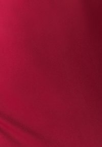 Raudona, tampri medžiaga su lygiu paviršiumi, vienos spalvos be raštų ar papuošimų. Vienodai krenta per visą paviršių.