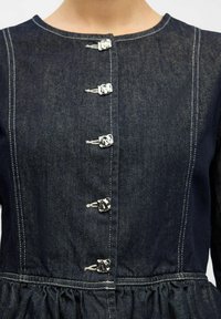 Denimklänning i mörk indigo med rund halsringning, knappstängning framtill med silverfärgade detaljer och rynkad midja för extra textur.