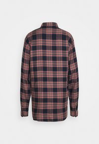 Rot-blau kariertes Hemd mit langen Ärmeln, Kragen und Knopfleiste. Weicher Stoff mit kariertem Muster, abgerundeter Saum am unteren Rand.