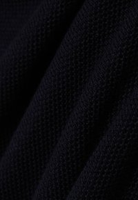 Donkerblauwe, gestructureerde brei stof met een losse weving, zichtbaar met plooien en diepten, geschikt voor kleding of accessoires.