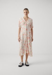 Rochie midi florală cu închidere cu nasturi în față, mâneci scurte cu volane și culori pastelate, având o croială lejeră și o margine ușor asimetrică.
