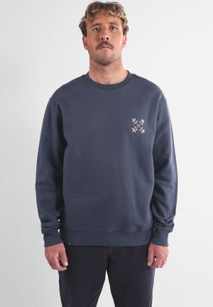 Sweat-shirt bleu marine en coton, doté d'un col rond, de poignets côtelés et d'un petit motif brodé en couleurs sur la poitrine.
