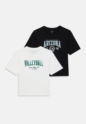 Kaks T-särki: üks valge rohelise tekstiga "VOLLEYBALL NEW YORK CITY EST. 1986" ja teine must sinise "ARIZONA" graafilise kujundusega.