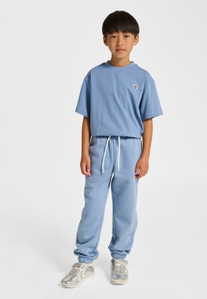 Jasnoniebieski, sportowy zestaw składający się z krótkiego bluzy z krótkim rękawem i zwężanych spodni dresowych, uzupełniony białym ściągaczem i mankietami.