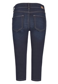 Tmavomodré džínsy so slim fit, skrátenou dĺžkou a kontrastným svetlým šitím. Obsahujú dve zadné vrecká a detail na páse.