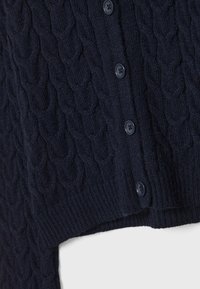 Mörkblå stickad cardigan med ett texturerat kabelmönster, utrustad med sex mörka knappar för stängning och en ribbad nederkant.