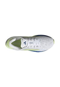 Baskets de sport blanches avec une tige en tissu texturé, des accents vert clair et une semelle bleue. Présente un design à lacets et un logo imprimé.
