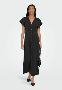 Robe noire midi à boutons, avec un décolleté en V et des manches courtes. Fabriquée en tissu léger, elle présente un léger resserrement à la taille.