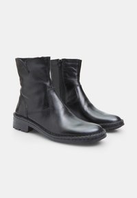 Black leather ankle boots with rounded toes, side zippers, and textured upper. Sturdy rubber soles with visible stitching detail.