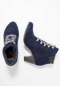 Navyblauwe suède enkellaarsjes met gestreepte veters, zilveren beslag, rits en een textuurblokhak. Voorzien van een gevoerde binnenvoering met demping.