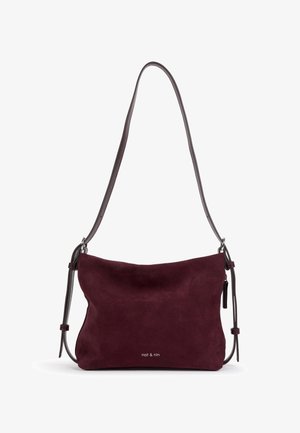 Sac à bandoulière en daim bordeaux foncé avec fines bretelles réglables et petit logo argenté "nat & nin" au centre devant.