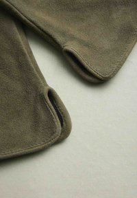 Olive green fleece fabric with rounded edges and openings. Soft texture, visible stitching, two overlapping pieces positioned close together.