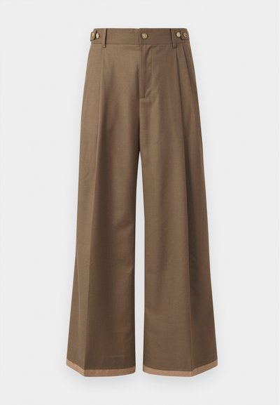 Wide-leg trousers in a dark brown fabric, featuring two side pockets, two decorative front buttons, and a contrast hem detail.