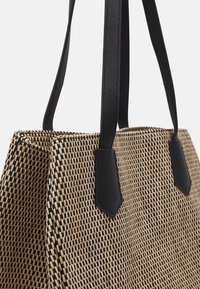 Sac fourre-tout en paille tissée avec des accents et des poignées en cuir synthétique noir, doté d'une ouverture sans fermeture et d'une forme structurée. Motif texturé sur toute la surface.