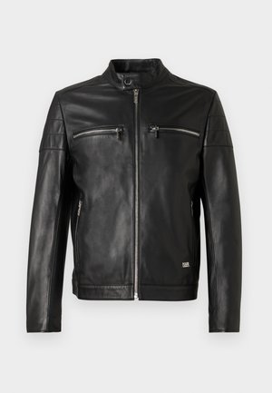 Schwarze Lederjacke mit Stehkragen, zwei mit Reißverschluss versehenen Brusttaschen und schlankem Design. Mit horizontalen Nähten an den Schultern.