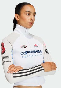 Climacool vit sportjacka med blå accenter och svarta ränder. Har logotryck på ärmar och krage. Texturerat tyg. Dragkedjestängning.