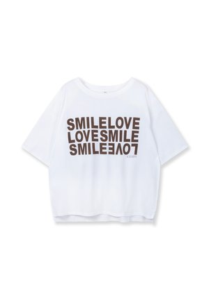 White cropped t-shirt made of soft fabric featuring bold brown text "SMILE LOVE LOVESMILE" in varied orientations. Rounded neckline, short sleeves.