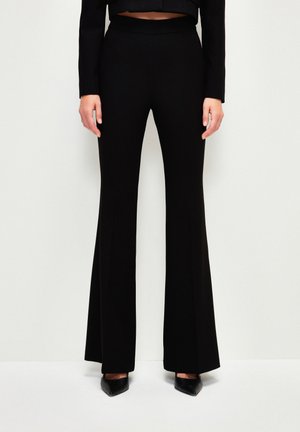 Pantalons noir évasés avec une taille ajustée et élégante, fabriqués dans un tissu lisse et extensible. Présentent un design à longueur complète avec un léger éclat.