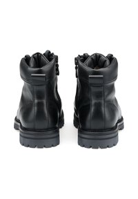 Bottines en cuir noir avec un bout arrondi, fermeture à glissière sur le côté, col rembourré et semelle en caoutchouc texturé avec des crampons profonds.