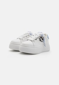 Vita sneakers med texturerad gummisula, rund tå, snörning och blå accenter på hälen och tungan. Utrustad med en dekorativ berlock.