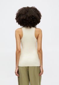 Fitted sleeveless top in light beige ribbed knit, featuring a high neckline and narrow shoulder straps, viewed from the back.