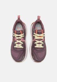 Scarpe da corsa in mesh viola con lacci gialli, accenti arancioni e dettagli testurizzati. Suola leggera per ammortizzazione e supporto.