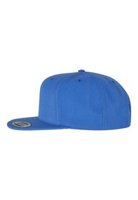 Kék baseball sapka lapos karimával, textúrált anyagból készült, szellőző lyukakkal és logó folttal az alsó részen.