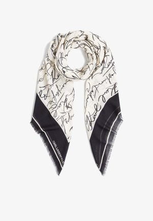 Svart och vit scarf med abstrakt handskriven mönster, mjukt tyg, triangulär form, fransar i kanterna, med en solid svart sektion i botten.